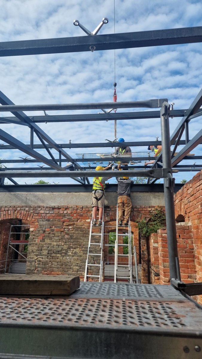 Glass roof panels installed on a steel structure over a historic palace